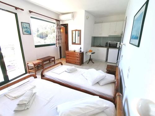 - 2 lits dans une chambre avec cuisine dans l'établissement George Michalas (Vivaria Apartments), à Paleokastritsa