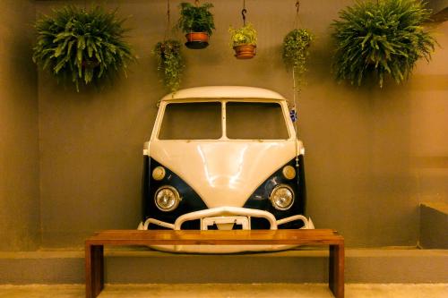 a car on display in a room with potted plants at Joy Hostel & Suítes in Brasilia