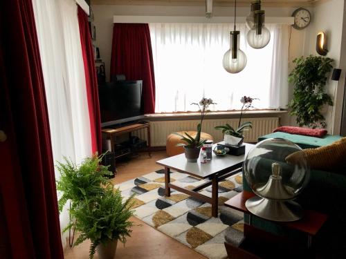 a living room with a couch and a table at Retro Relax Resort midden in het bos op de Veluwe in Putten in Putten