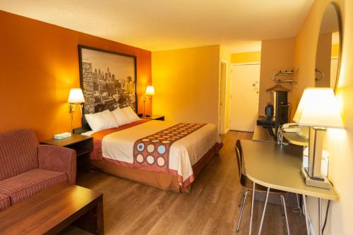 a hotel room with a bed and a desk at Super 8 by Wyndham Carlisle North in Carlisle