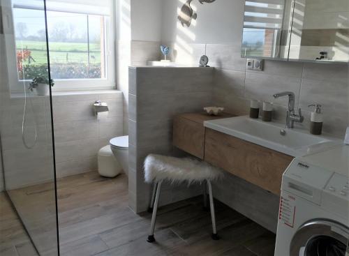 a bathroom with a sink and a washing machine at Ferienwohnung Storchenblick in Zurow