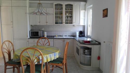 eine Küche mit einem Tisch und Stühlen sowie eine Küche mit weißen Schränken in der Unterkunft Bellavista in Porto Valtravaglia