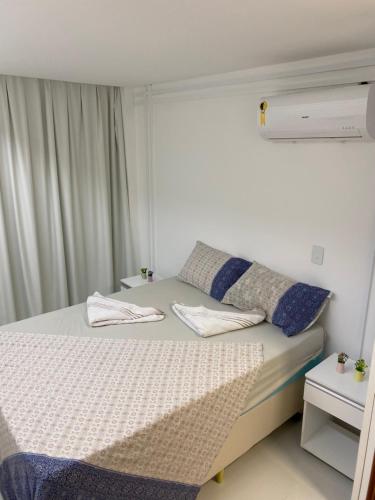 ein Schlafzimmer mit einem Bett mit zwei Kissen darauf in der Unterkunft Condomínio Solar Porto Rico AP 3 in Porto De Galinhas
