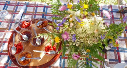 a table with a vase of flowers and spoons at Guest house PANORAMA in Theth