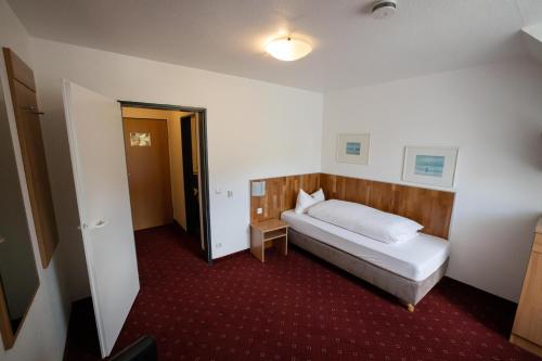 a hotel room with a bed and a hallway at Hotel Wittgensteiner Hof in Bad Laasphe