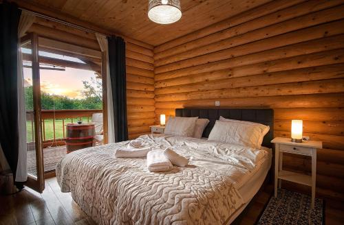 1 dormitorio con 1 cama en una cabaña de madera en Country Lodge Vuković en Rakovica