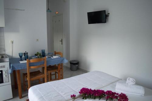 una habitación con una cama y una mesa con flores. en Armenaki Apartments, en Sampatiki