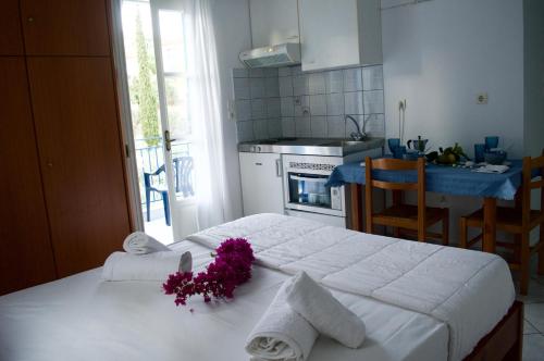a kitchen with a bed with purple flowers on it at Armenaki Apartments in Sampatiki