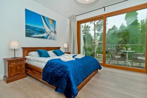 sypialnia z łóżkiem i dużym oknem w obiekcie BlueApart Oaza Jurata w Juracie