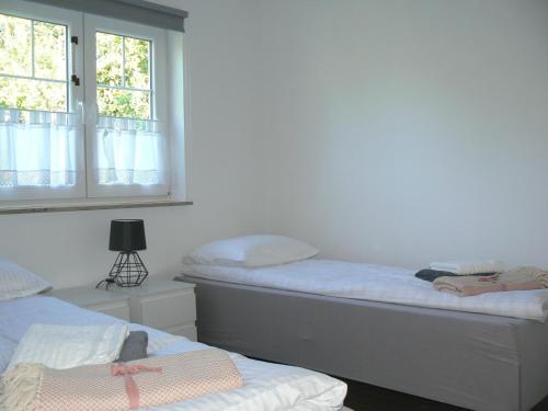 1 dormitorio con 2 camas y ventana en Blue house, en Suchedniów