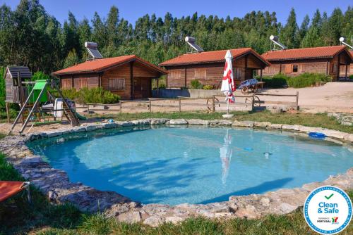 a large pool in front of a log cabin at Quintinha do Casal Ruivo in Figueiró dos Vinhos
