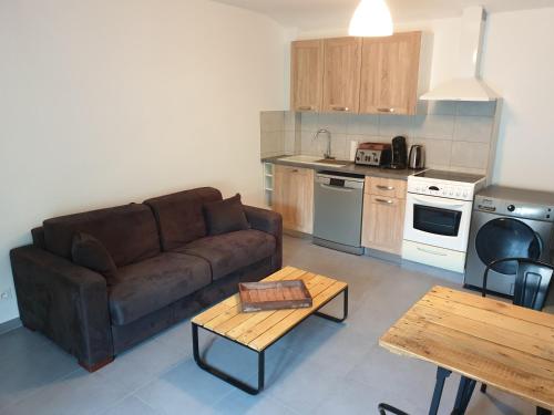 ein Wohnzimmer mit einem Sofa und einem Tisch in der Unterkunft Atelier n°4 in Fontaine-de-Vaucluse