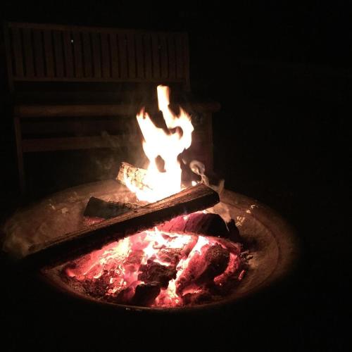 a fire pit with some food in it at Countryside Cottages in Bartonsville