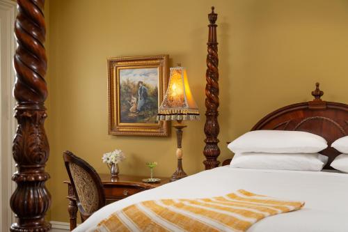 a bedroom with a bed and a table with a lamp at The Inn on West Liberty in Savannah