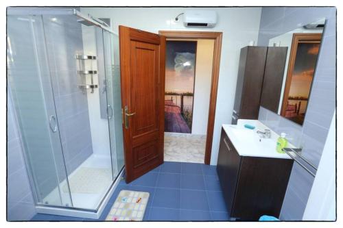 a bathroom with a shower and a wooden door at Cova Do Raposo in Lagarteira