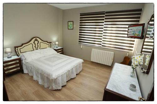 a bedroom with a bed and a table and a window at Cova Do Raposo in Lagarteira