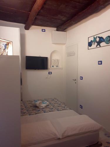 a bedroom with a bed and a flat screen tv at La casa nella Torretta in Formia