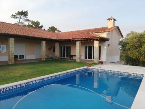 a swimming pool in front of a house at Villa Gomes Pedro in Tomar