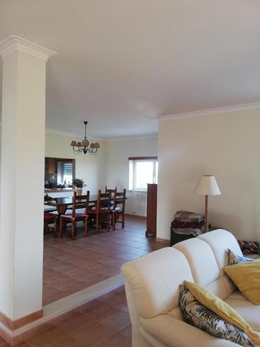 a living room with a white couch and a dining room at Villa Gomes Pedro in Tomar
