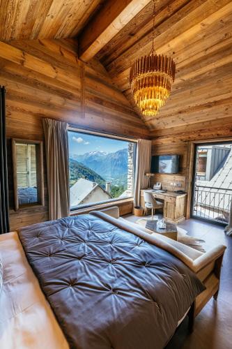 une chambre avec un grand lit et une grande fenêtre dans l'établissement Hotel Le V de Vaujany, à Vaujany