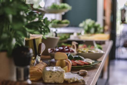 a buffet line with cheese and food on a table at TOP Garden Aparthotel in Toruń