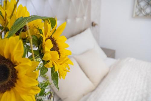 a vase filled with yellow flowers next to a couch at Casa PERLA in Dunajská Streda