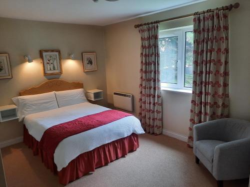 a bedroom with a bed and a chair and a window at Sea Dew B&B in Tullamore