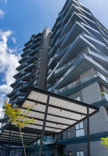 a tall building with a glass canopy in front of it at FR Hotel in Ibagué