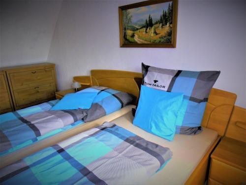 een slaapkamer met 2 aparte bedden en een foto aan de muur bij Familienfreundliches Ferienhaus mit 3 Schlafzimmern in Oldisleben