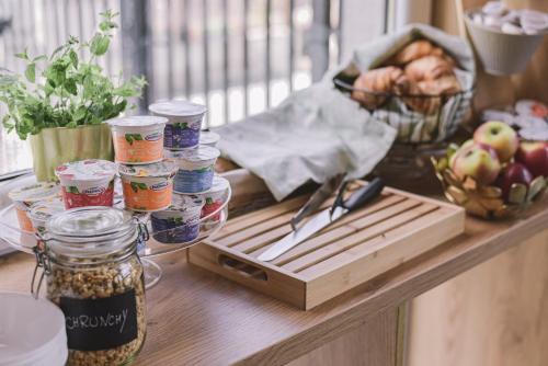 a table with jars of food and a basket of apples at TOP Garden Aparthotel in Toruń