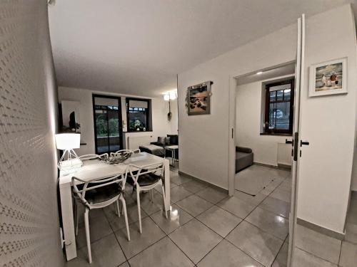 a dining room with a white table and chairs at Apartamenty Aleksandry Apartament przy Parku in Świnoujście
