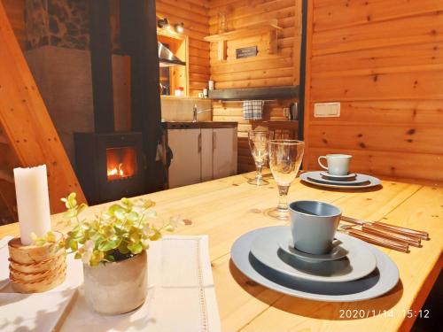 KarlstenにあるCottage On Wild River In Lapland/Swedenの木製テーブル(皿、カップ付)、暖炉