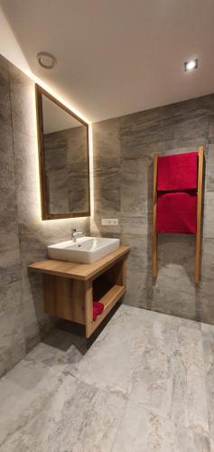 a bathroom with a sink and a red towel at HIESERHOF - Superior Alpine Apartments in Heiligenblut