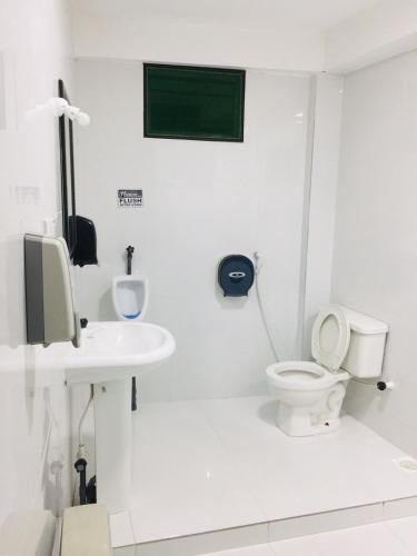 a white bathroom with a toilet and a sink at Senthil Complex in Jaffna
