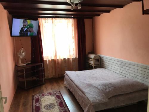 um quarto com uma cama, uma televisão e uma janela em Apartament Andreea em Târgu-Mureş