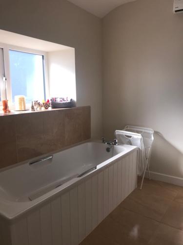 a large bath tub in a bathroom with a window at Eileen's House in Cork