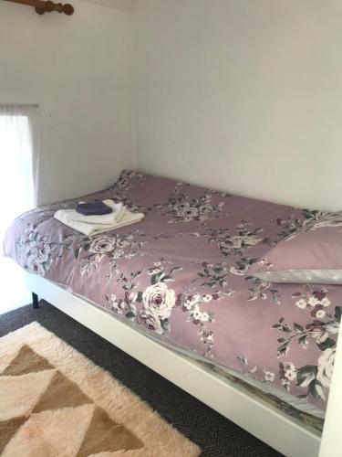 Una cama con colcha púrpura con flores. en Eileen's House en Cork