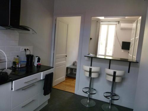 - une cuisine avec un miroir et deux tabourets dans l'établissement Studio Calme avec Jardin, Tram T6 et Métro D, Lyon 8, à Lyon