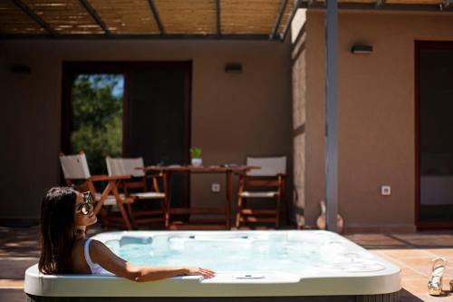 Eine Frau, die in einem Whirlpool auf einer Terrasse sitzt in der Unterkunft Klaritz Luxury Suites in Lassi