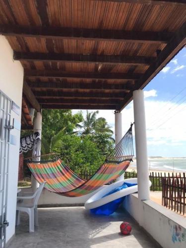 a hammock and a chair on a porch at Praia da Baleia Itapipoca CE in Franco