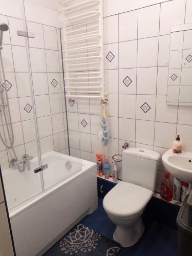 Mieszkanie dwupokojowe Kołobrzeg-Podczele في كولوبرزيغ: حمام مع مرحاض وحوض استحمام ومغسلة