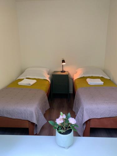 2 letti in una stanza con vaso di fiori di Gouden Hert: relaxen in comfort! #otterlo #hogeveluwe a Otterlo