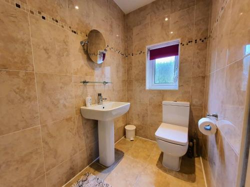 ein Badezimmer mit einer weißen Toilette und einem Waschbecken in der Unterkunft Bronte Cinema Cottage At Haworth in Haworth