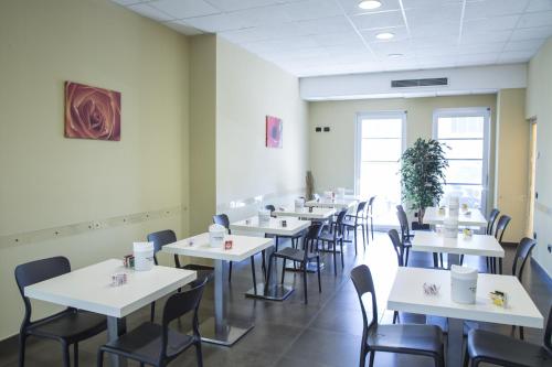 une salle à manger avec des tables et des chaises blanches dans l'établissement Hotel Motel Giglio, à Viadana