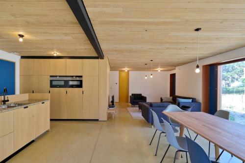 eine Küche und ein Wohnzimmer mit einem langen Holztisch in der Unterkunft Duinvis 13 in Oostduinkerke