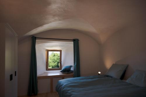 Schlafzimmer mit einem Bett und einem Fenster in der Unterkunft MaisonNel Gîte in Saint-Bonnet-en-Champsaur