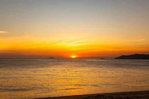 a sunset on the beach with the sun setting at Pousada Aparas in São Sebastião