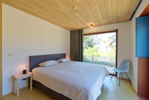 a bedroom with a large bed and a window at Duinvis 15 in Oostduinkerke