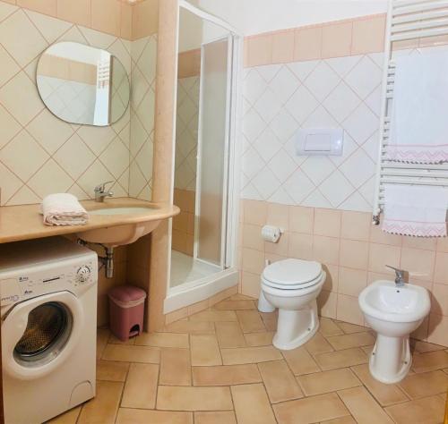y baño con lavamanos y lavadora. en Appartamento con Vista Panoramica, en Baunei