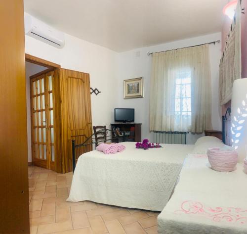 1 dormitorio con 2 camas, TV y ventana en Appartamento con Vista Panoramica en Baunei
